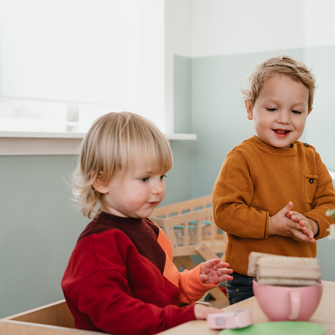 Twee kinderen spelen aan tafel met speelgoed