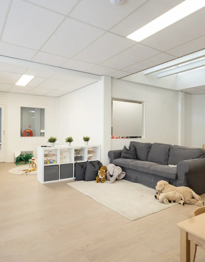 binnenruimte met bank en speelmateriaal kinderopvang