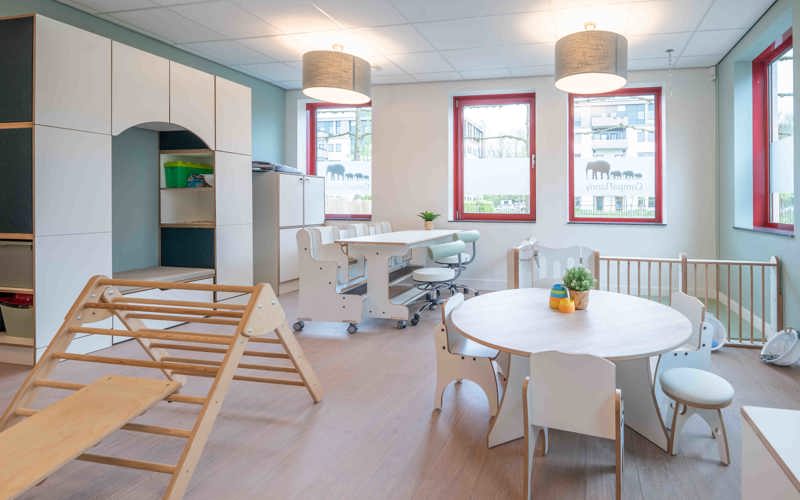 babygroep inrichting met houten meubels grondbox en klimdriehoek