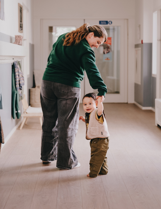 Kind loopt samen met pedagogisch professional 