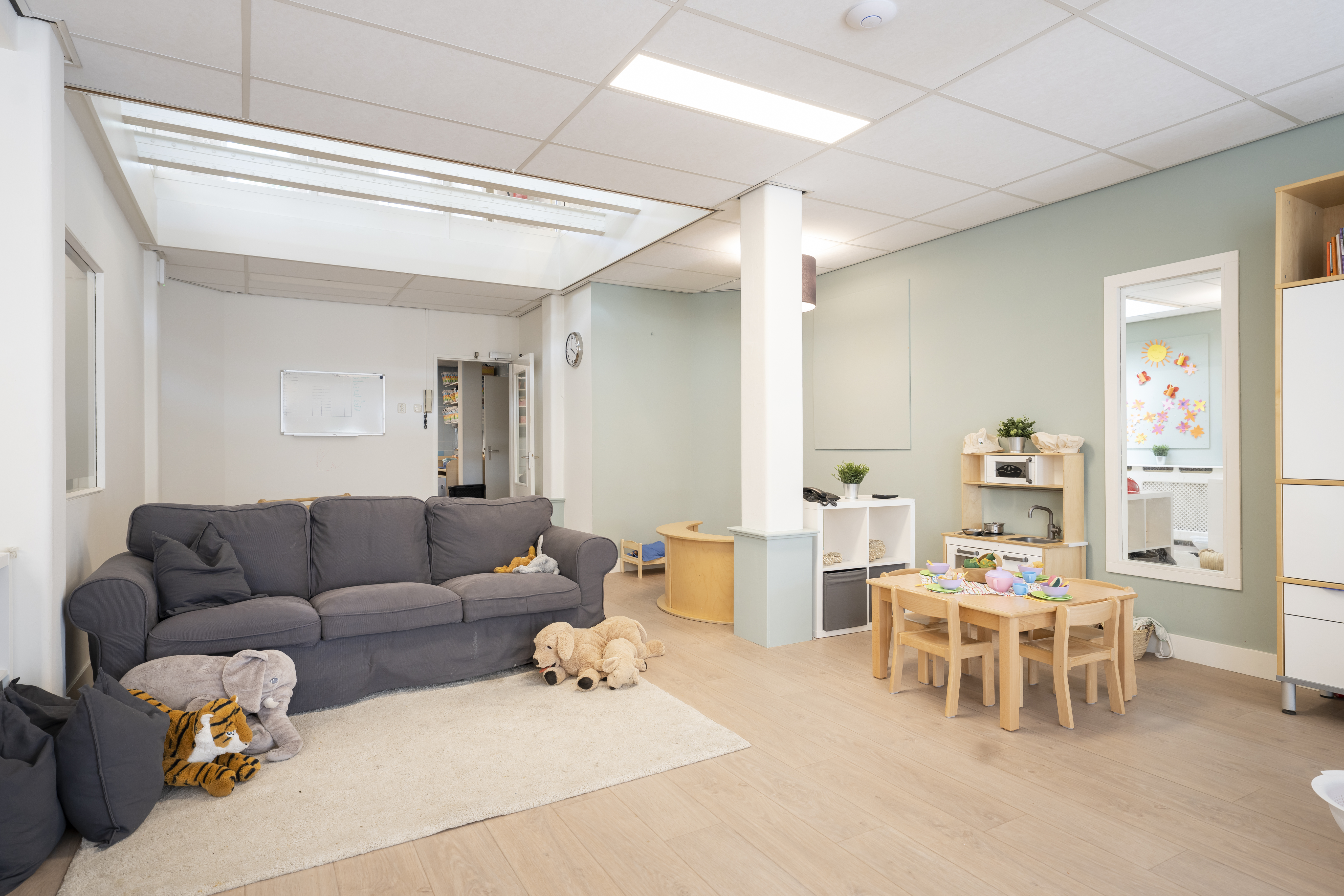 binnenruimte met bank en speelmateriaal kinderopvang 