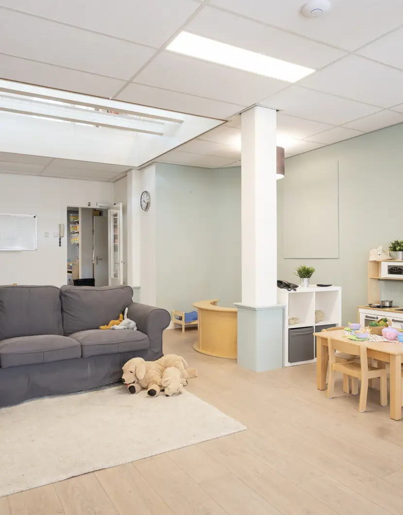 binnenruimte met bank en speelmateriaal kinderopvang