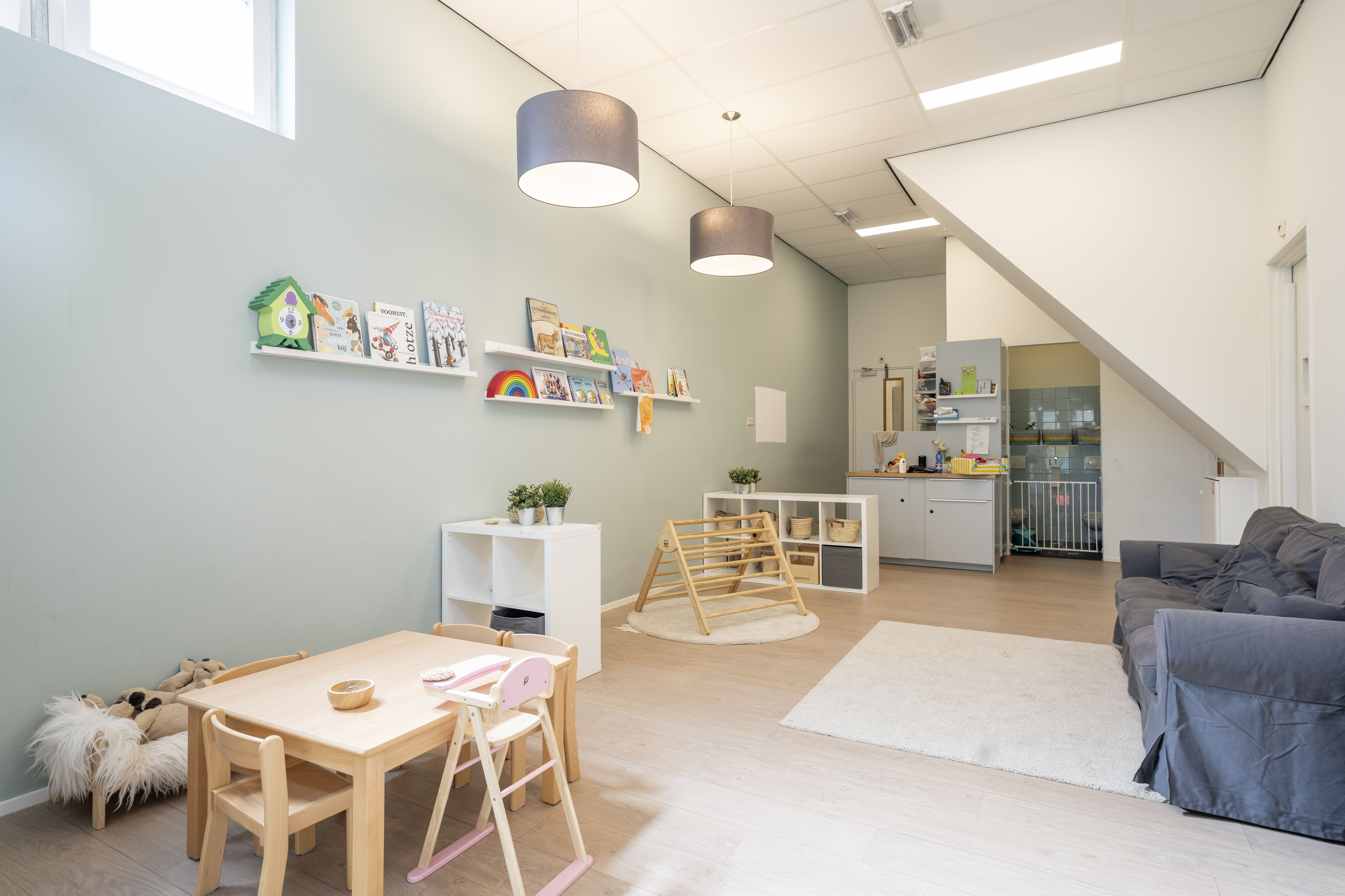 babygroep binnenruimte kinderopvang met spelmateriaal klimtoestel tafel stoelen en bank