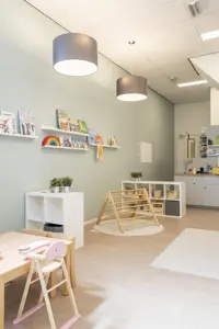 babygroep binnenruimte kinderopvang met spelmateriaal klimtoestel tafel stoelen en bank