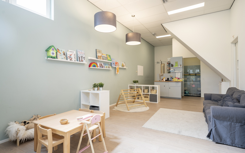 babygroep binnenruimte kinderopvang met spelmateriaal klimtoestel tafel stoelen en bank