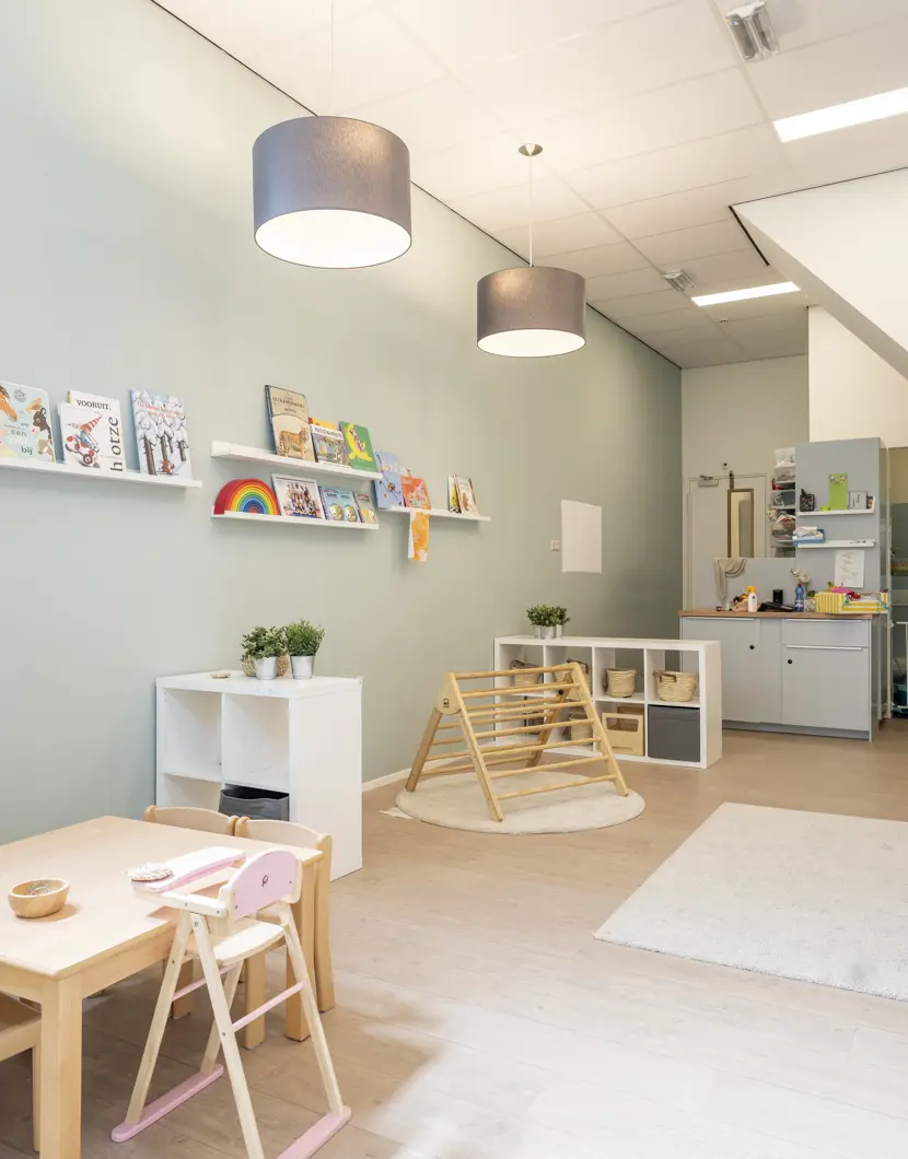 babygroep binnenruimte kinderopvang met spelmateriaal klimtoestel tafel stoelen en bank