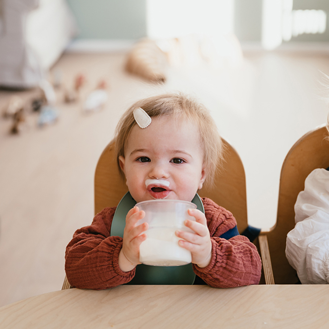 Baby eet eerste hapje voeding op kinderopvang