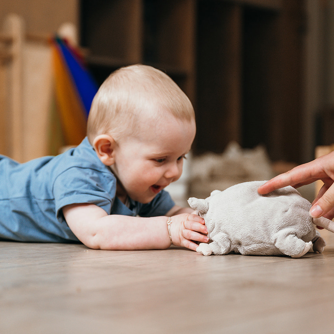 Baby speelt op de grond met knuffel