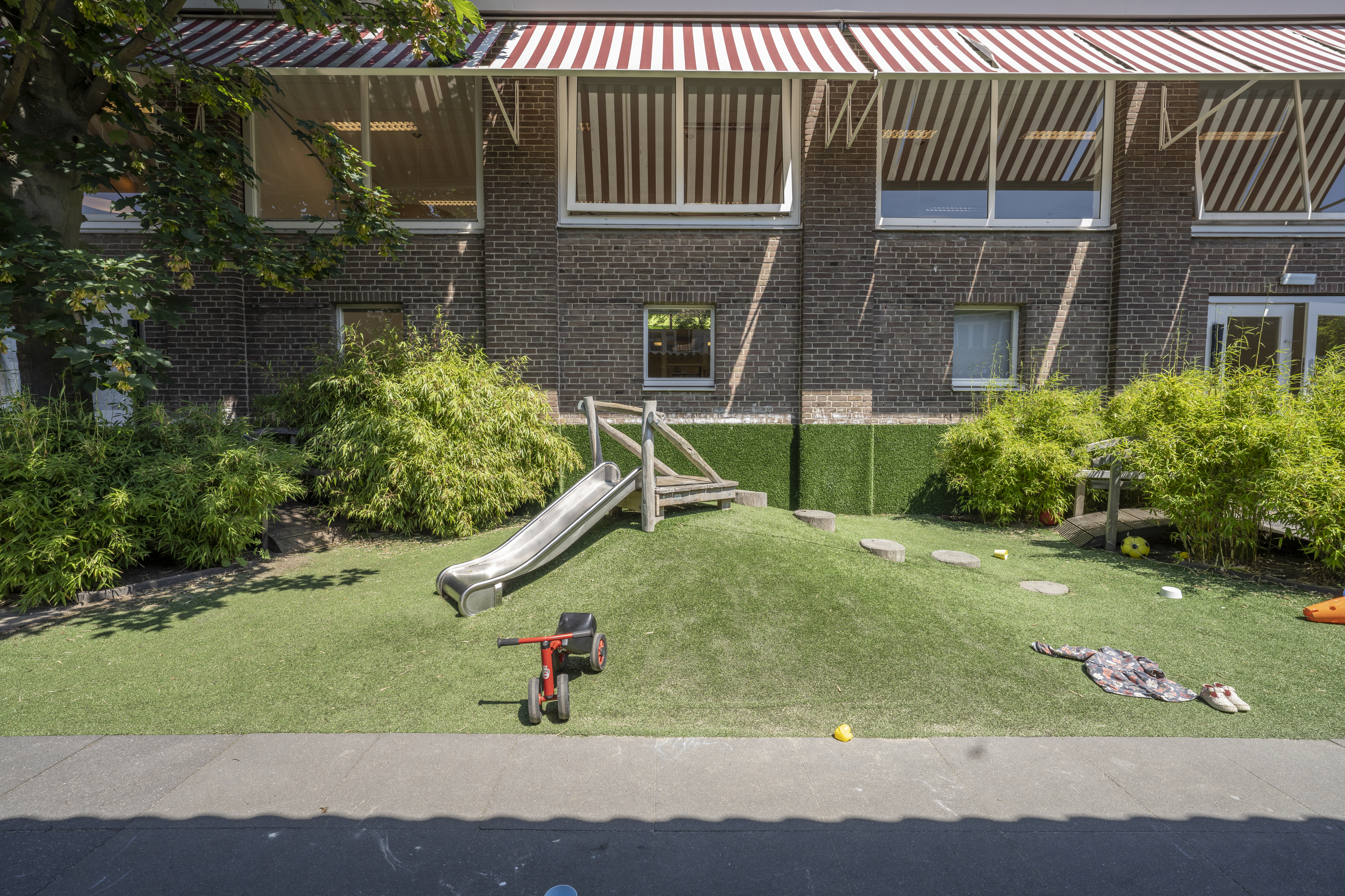 Tuin met glijbaan kinderopvang CompaNanny Kleverpark Haarlem