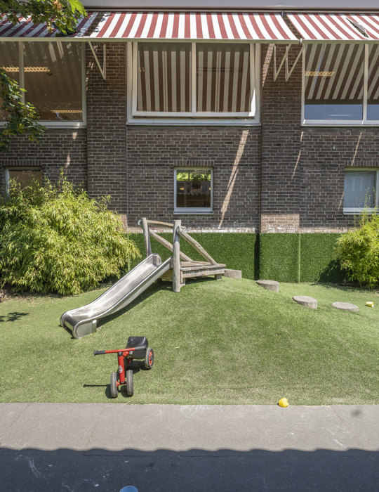Tuin met glijbaan kinderopvang CompaNanny Kleverpark Haarlem