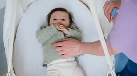Baby ligt in craddle 