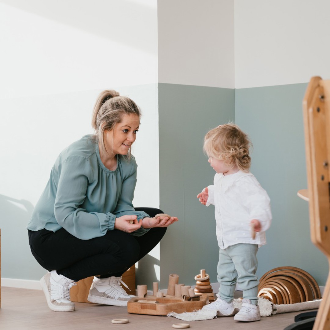 Vrouw laat speelgoed zien aan kind