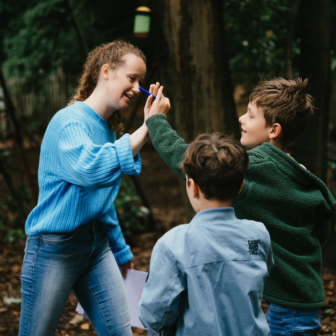 Pedagogisch Medewerker geeft high five aan kinderen positieve opvoeding