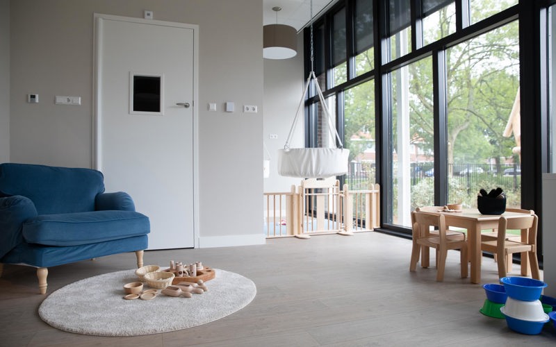 inrichting babygroep met grondbox loungestoel en houten spelmaterialen