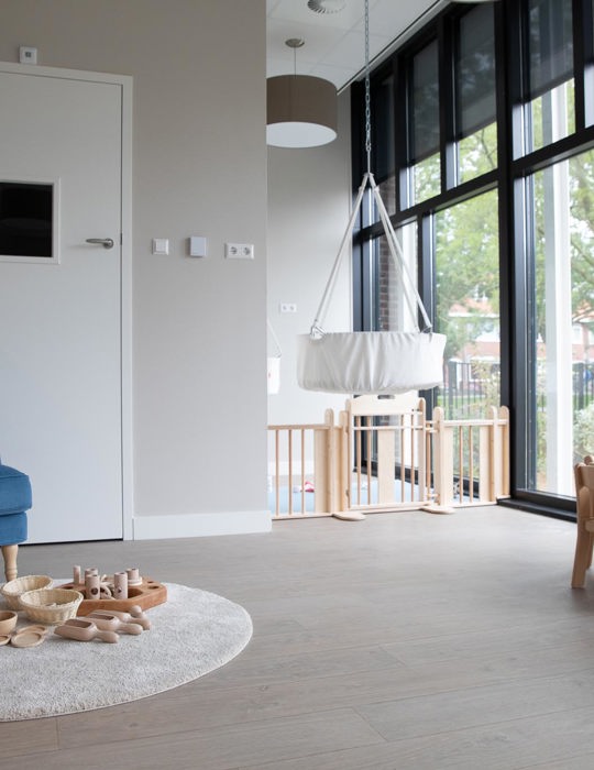 inrichting babygroep met grondbox loungestoel en houten spelmaterialen