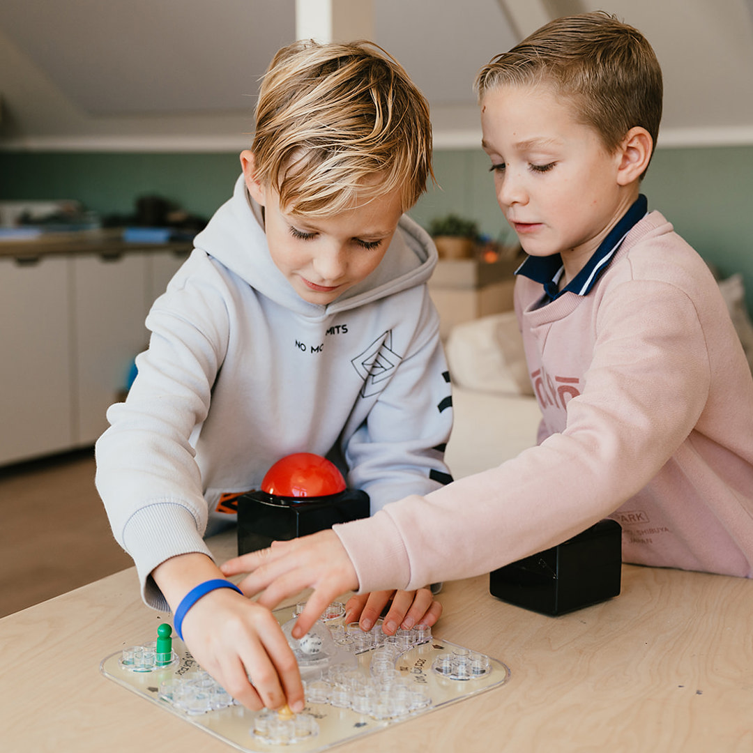 Twee jongens spelen een spel aan tafel
