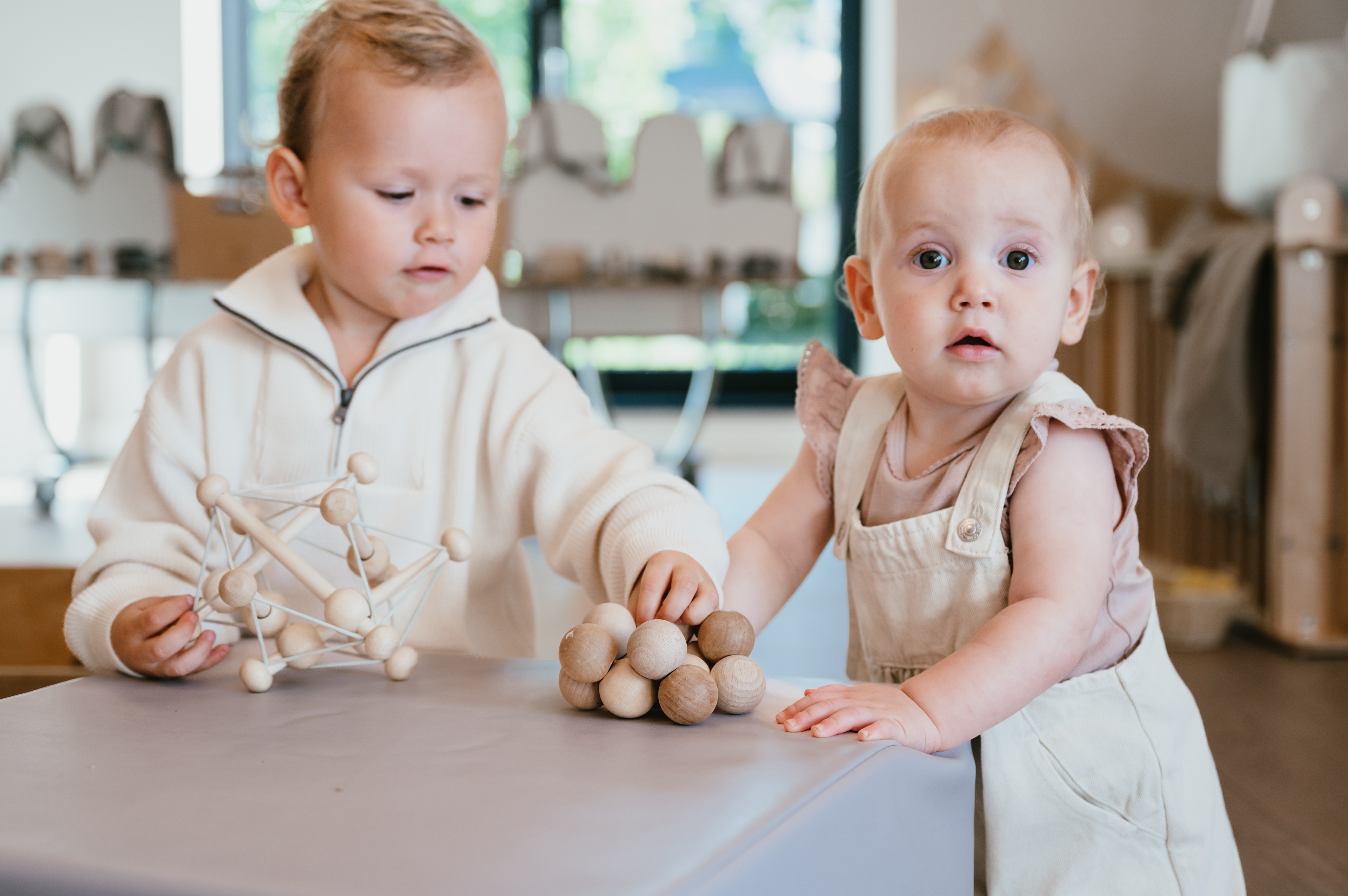 Baby en dreumes spelen samen op kinderdagverblijf