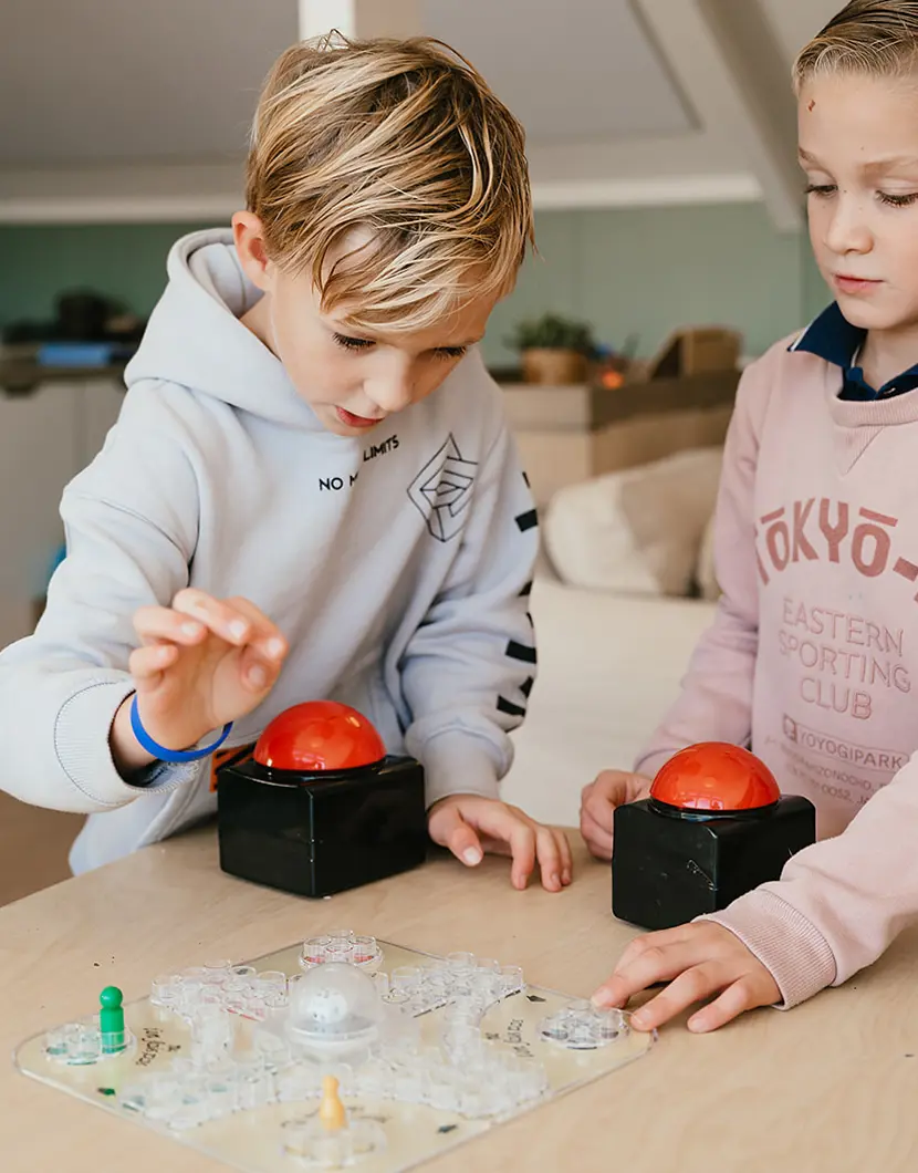 Twee jongens spelen een spel aan tafel