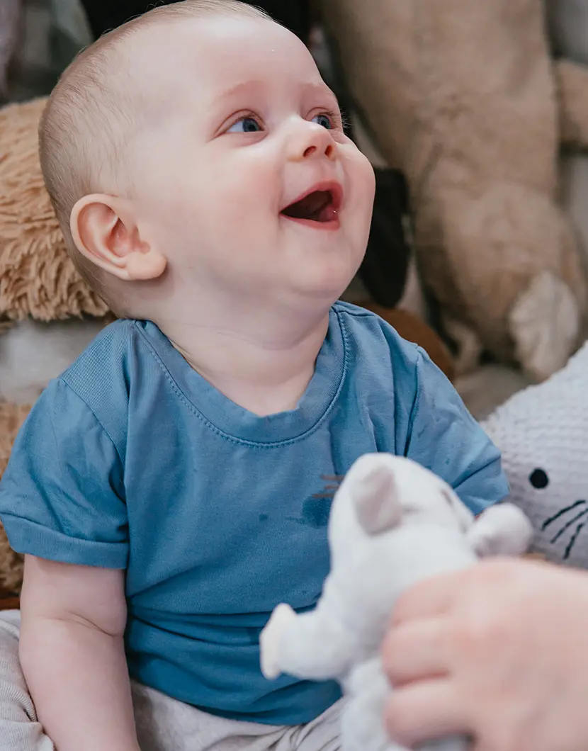 Baby kijkt omhoog en lacht