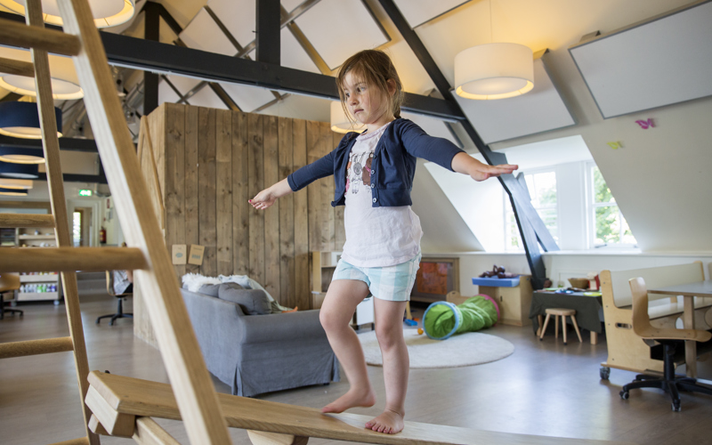 Meisje speelt op Pikler klimrek