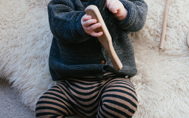 baby ligt op kleed en kijkt blij